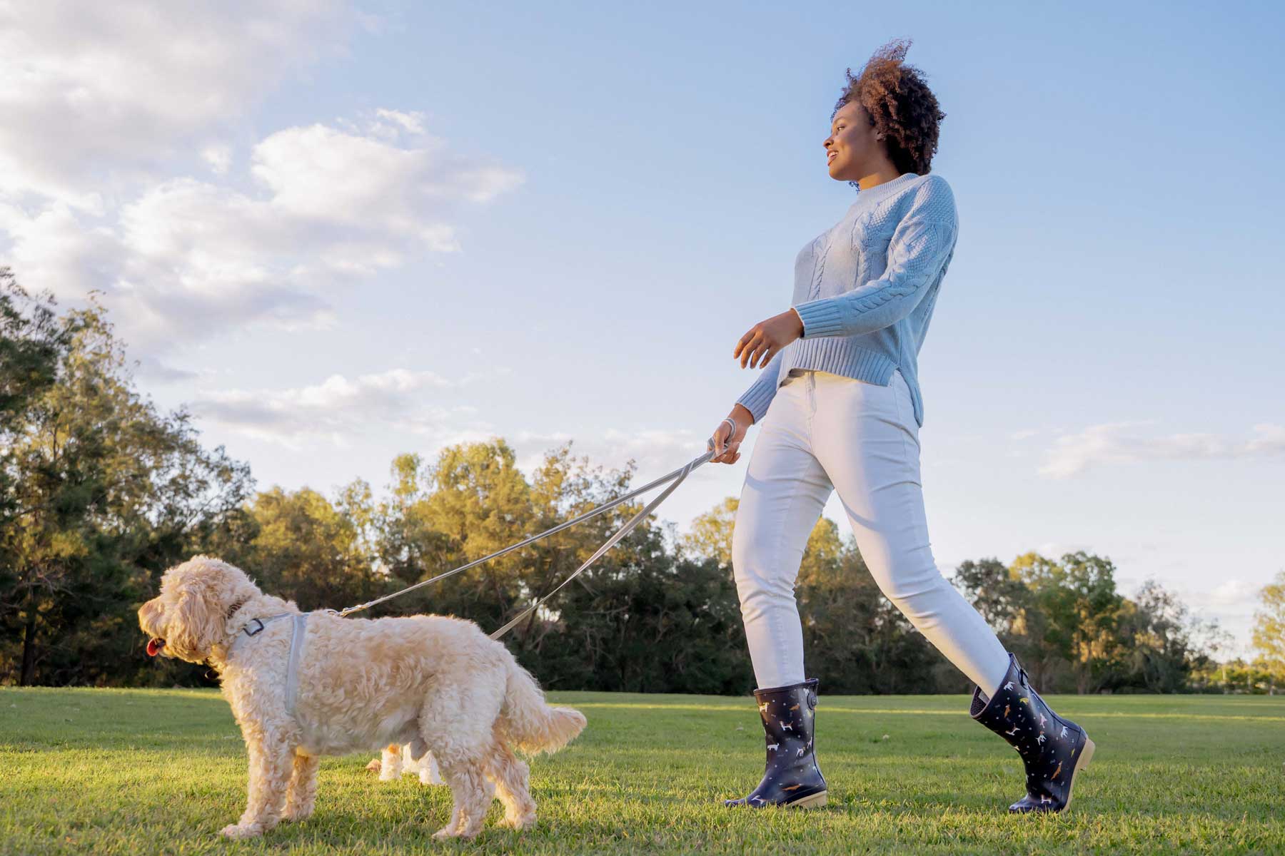 Model wearing gumboots while walking her dog