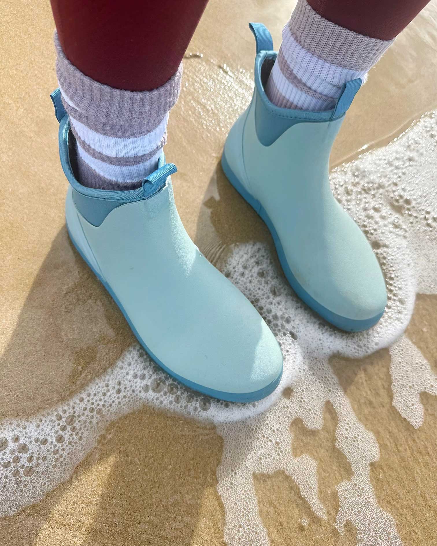 standing in beach water wearing gumboots